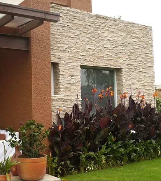 Fachada con piedra y jardín